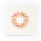 A cream-colored Christmas card with deckled edges, featuring a festive holly wreath design made of gold leaves and bright red berries.