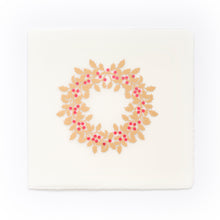 A cream-colored Christmas card with deckled edges, featuring a festive holly wreath design made of gold leaves and bright red berries.