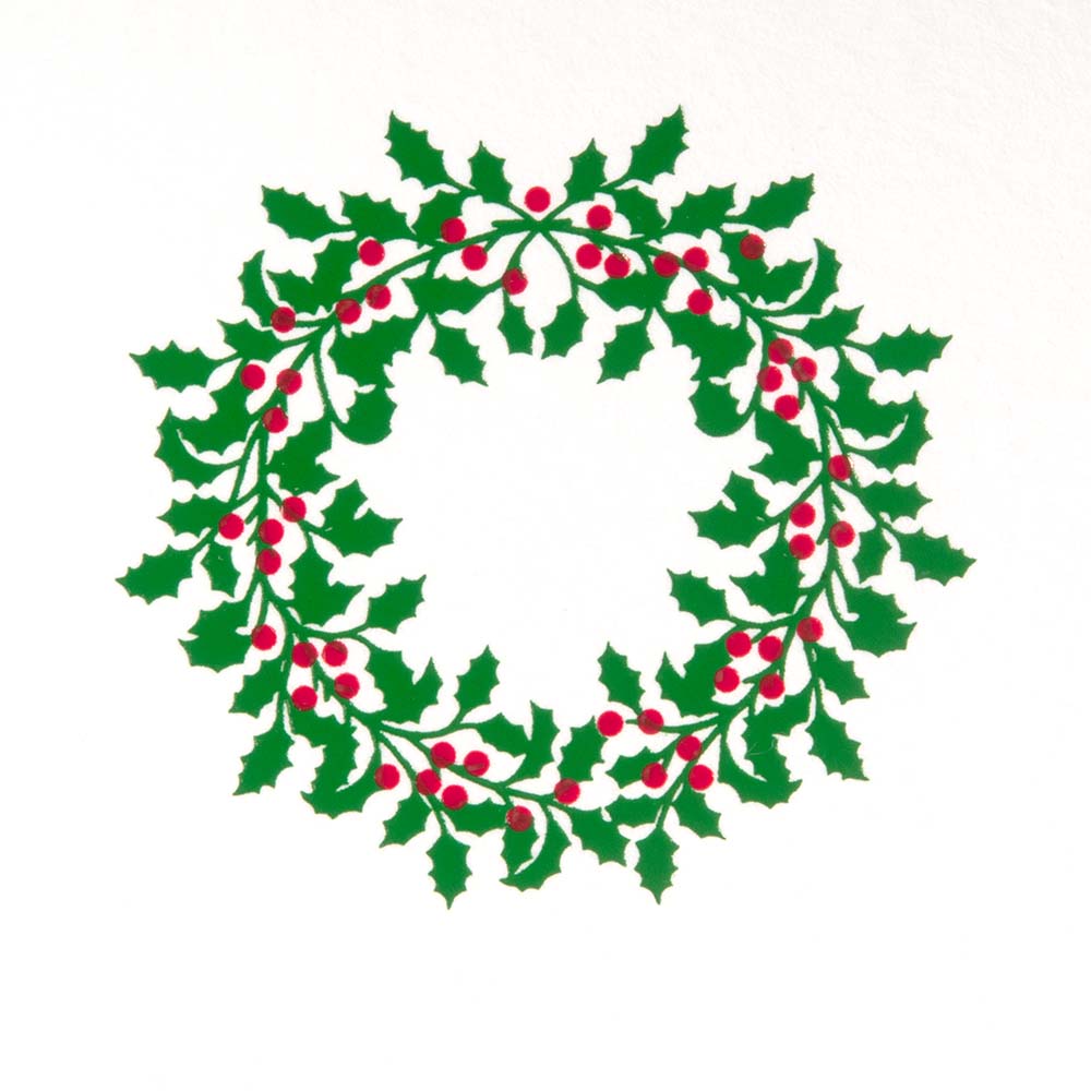 A close-up of a white Christmas card featuring a green holly wreath with red berries.