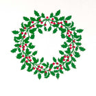 A close-up of a white Christmas card featuring a green holly wreath with red berries.