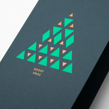A close-up of a modern dark green Christmas card with a geometric Christmas tree design made of green and gold triangles, reading "Merry Xmas" in gold.