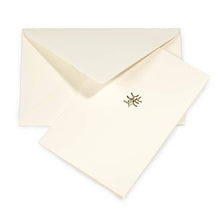 A cream-colored Christmas card with a small mistletoe sprig of olive leaves and pink berries in the center, shown with a matching cream envelope.
