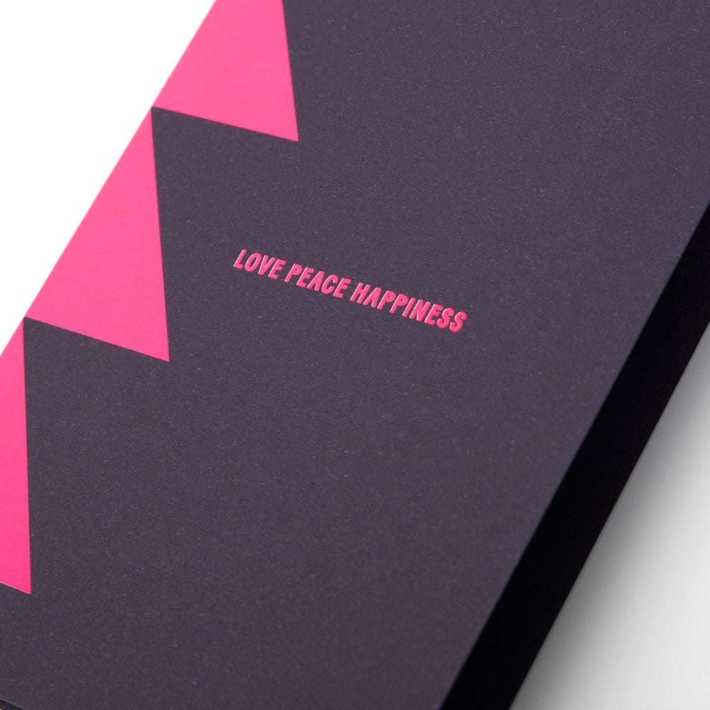 A close-up of a sleek dark card with neon pink triangle accents and the words LOVE PEACE HAPPINESS in the center.