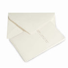 Minimalist Christmas card made from textured cream deckle-edged paper, featuring delicate gold lettering that reads “Merry Christmas and Happy New Year,” paired with a matching cream envelope.