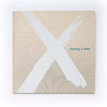 Christmas card with a bold white brushstroke “X” on a gold background and the text “merry x-mas” in small green letters.