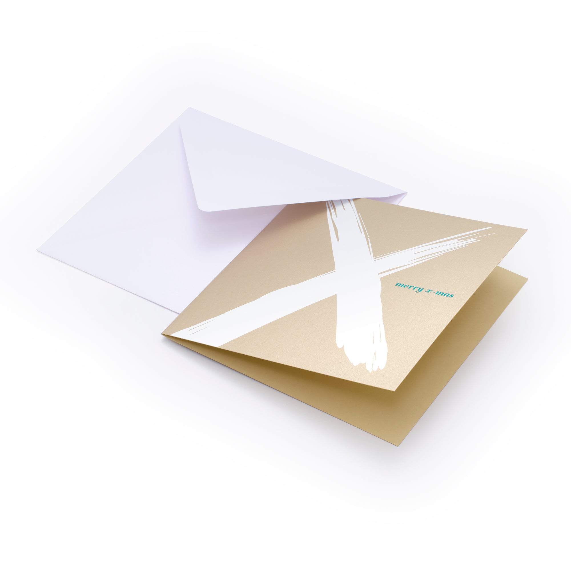 Christmas card with a bold white brushstroke “X” on a gold background and the text “merry x-mas” in small green letters, paired with a plain white envelope.
