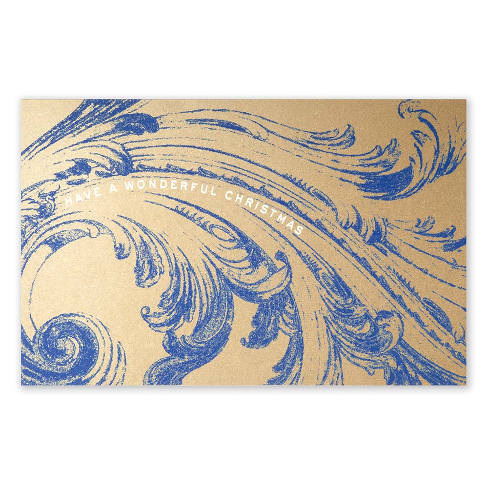 A brown kraft paper Christmas card decorated with an elaborate blue ornamental swirl pattern and the greeting "HAVE A WONDERFUL CHRISTMAS".