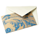 A brown kraft paper Christmas card decorated with an elaborate blue ornamental swirl pattern and the greeting "HAVE A WONDERFUL CHRISTMAS," paired with a cream envelope.