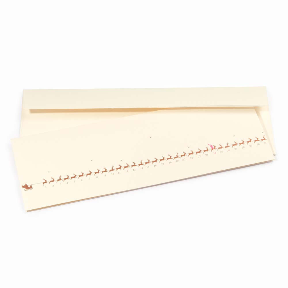 Minimalist cream-colored Christmas card showing a row of small gold reindeer pulling a sleigh, numbered up to 31. The reindeer on the 24th is marked in red. Paired with a matching cream envelope.