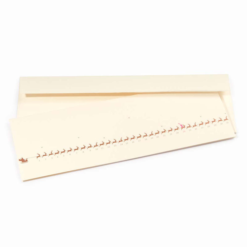 Minimalist cream-colored Christmas card showing a row of small gold reindeer pulling a sleigh, numbered up to 31. The reindeer on the 24th is marked in red. Paired with a matching cream envelope.