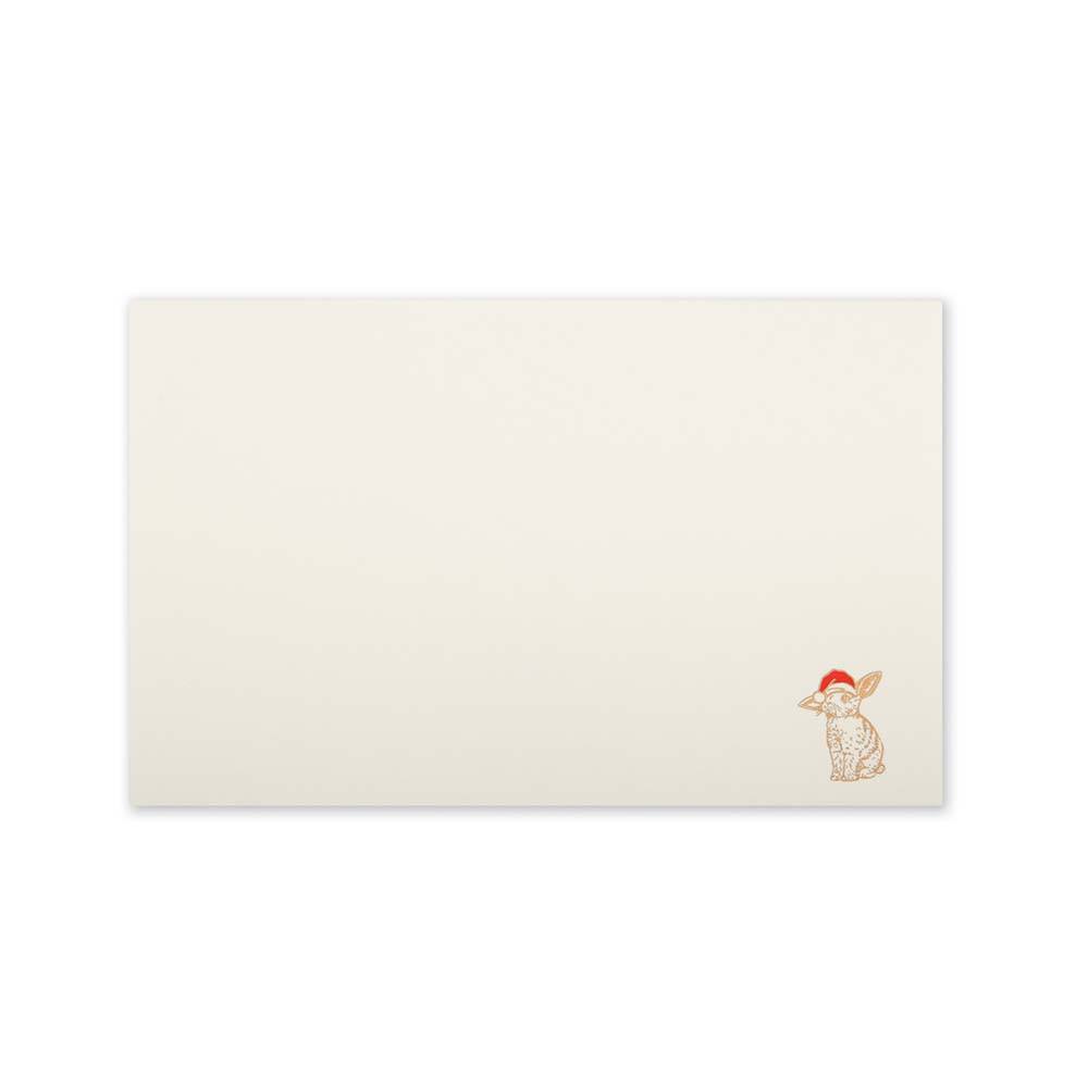 Minimalist cream-colored Christmas card with a small illustration of a rabbit wearing a Santa hat in the bottom right corner.
