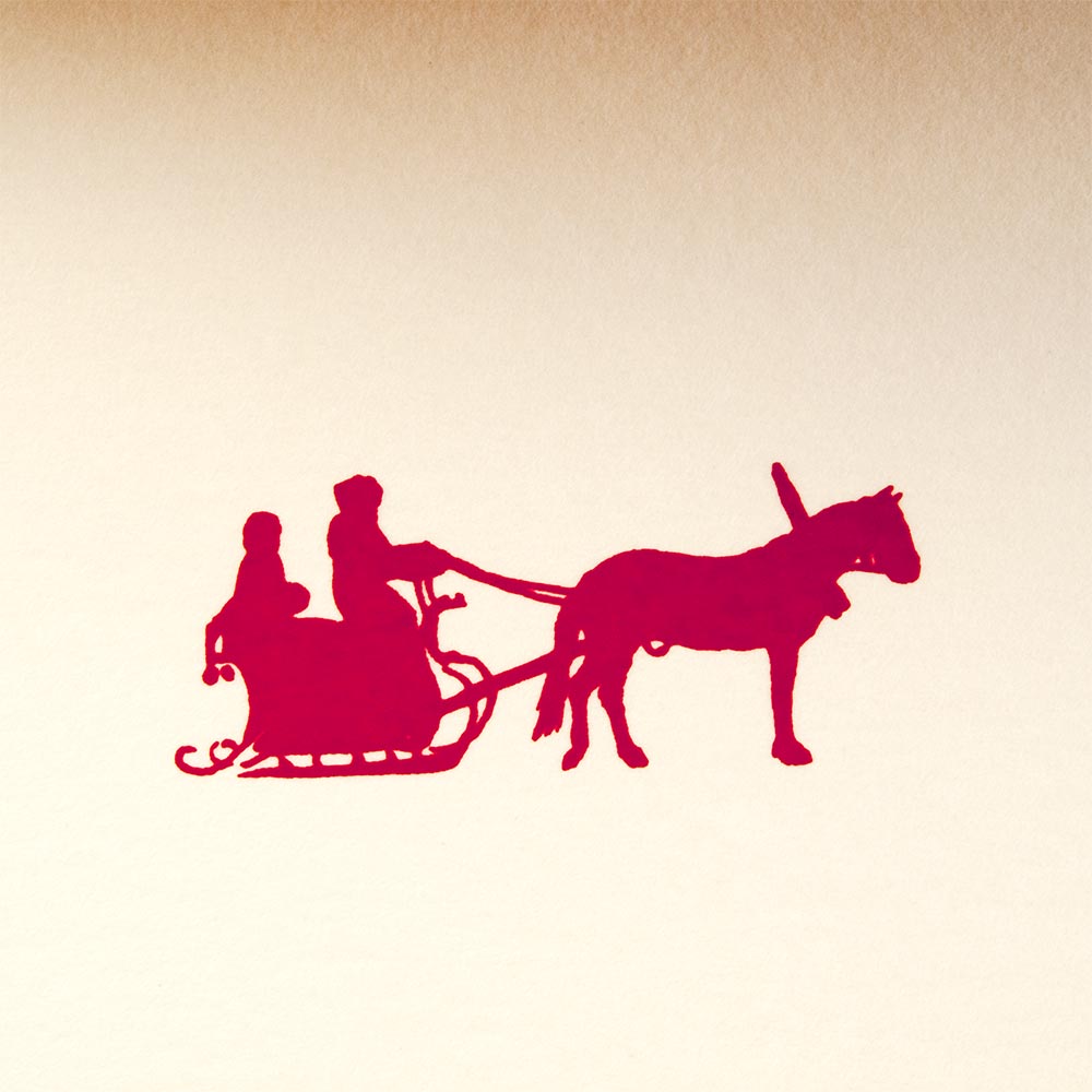 A close-up of a cream-colored Christmas card with red border, showing a red silhouette of Santa in a sleigh pulled by one reindeer.