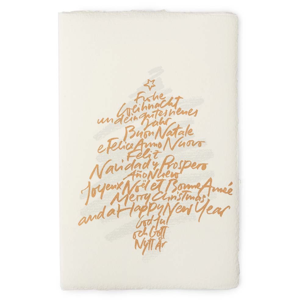 A cream-colored Christmas card with deckled edges, featuring a gold handwritten text design arranged in the shape of a Christmas tree with a small star on top.