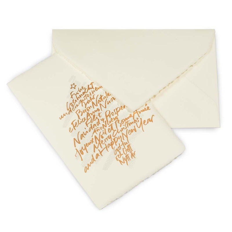 A cream-colored Christmas card with deckled edges, featuring a gold handwritten text design arranged in the shape of a Christmas tree with a small star on top, shown with a matching cream envelope.
