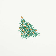 A close-up of a simple white Christmas card with a small decorated Christmas tree illustration in the center.