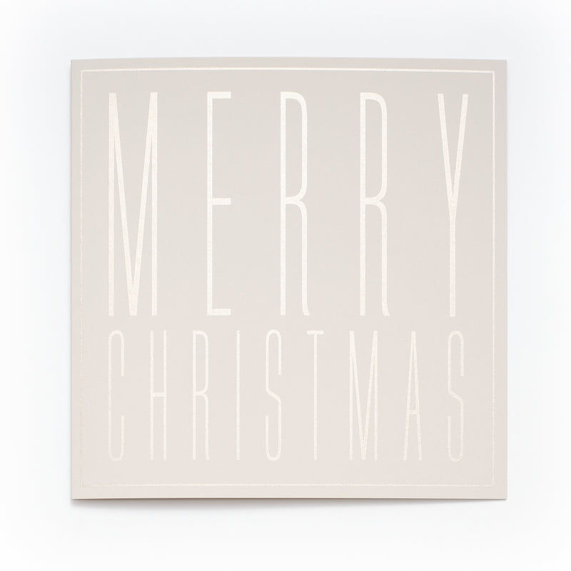 A square cream-colored Christmas card with embossed tall block letters spelling "MERRY CHRISTMAS".