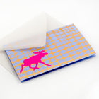 Modern Christmas card with a bright pink moose silhouette against a blue and gold grid-like background, paired with a translucent white envelope.